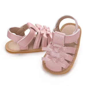 Primer plano de sandalias rosas brillantes para bebé con suela blanda