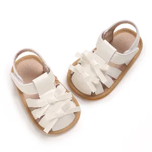 Detalle de sandalias blancas para bebés con elegantes lazos para niños de 0 a 1 años