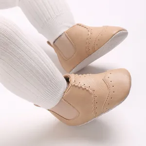 Khaki imitatielederen baby loopschoenen met decoratieve stiksels en zachte zolen aan babyvoeten