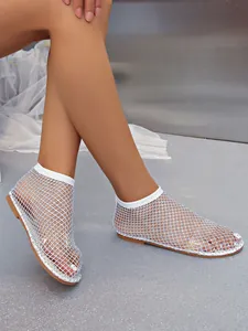 Détail des sandales blanches en maille ajourée avec strass scintillants pour l'été