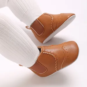 Detailopname van bruine baby wandelschoenen van zacht leer met elastische zijden en golf