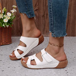 Primer plano detallado de las elegantes sandalias blancas con cuña y costuras decorativas