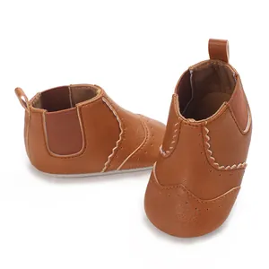 Detailopname van bruine baby-loopschoenen van kunstleer met decoratieve stikseldetails