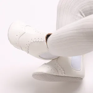 Detailopname van witte baby-loopschoentjes met zachte zool, gekartelde randen en antislipbodem