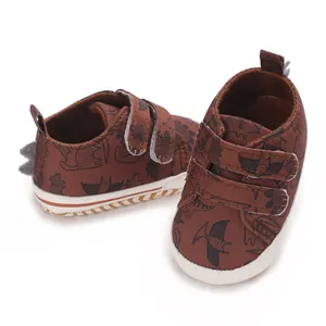Detailed view of brown baby dinosaur sneakers with velcro straps and soft sole