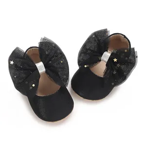 Detail van zwarte baby prinsessenschoenen met grote mesh strikken en gouden sterren