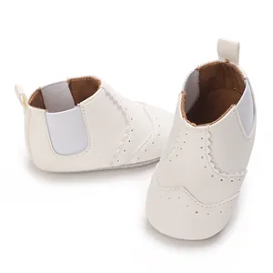 Witte babyschoentjes met zachte zool, brogue-details en elastische zijkanten