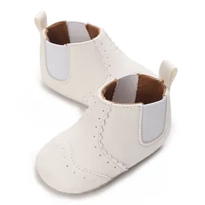 Detail van witte babyschoentjes met zachte zool en elegante details voor de eerste stapjes.