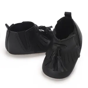 Detailansicht der schwarzen Baby-Schuhe mit schicken Quasten und weicher Stoffsohle
