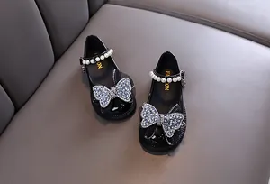 Detailansicht von schwarzen Lacklederschuhen für Mädchen mit Strassschleife und Perle