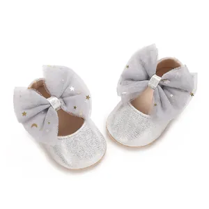 Detail van zilveren glitter babyschoentjes met grote strikken van sterrengaas