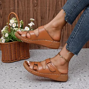 Vista lateral de sandalias de cuña marrones talla grande con diseño calado y costuras