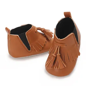 Detailansicht von braunen Baby-Fransenschuhen mit weichen Sohlen und Quasten-Dekor.