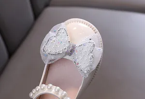 Detailansicht der Perlen- und Strassschleife an eleganten beigen Mädchen-Prinzessschuhen