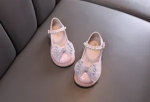 Detail der rosa Mädchen-Mary-Janes mit Perlenriemen und funkelnder Strass-Schleife