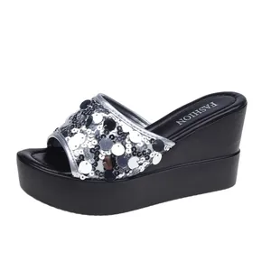 Elegant silver sequined wedge sandals featuring a stylish thick black platform sole
