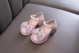 Nahaufnahme von rosa Prinzessinnenschuhen für Mädchen mit Strassschleifen und Perlen