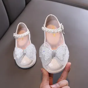 Eleganti ballerine bianche da bambina con cinturino di perle e grande fiocco di strass