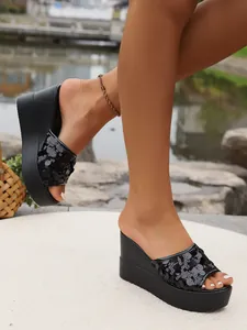 Professional detail shot of black sequin wedge platform sandals for women outdoors