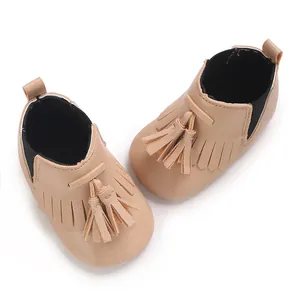 Detailansicht beige Baby-Hochschaftschuhe mit dekorativen Quasten und weicher Stoffsohle.