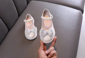 Detailansicht weißer Prinzessinnenschuhe für Mädchen mit Strassschleife und Perle