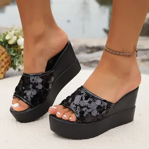 Detailed view of black sequined wedge sandals featuring a high platform and open toe