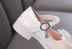 Detailansicht der cremefarbenen Mädchen-Prinzessinenschuhe aus Lackleder mit Perlenriemen