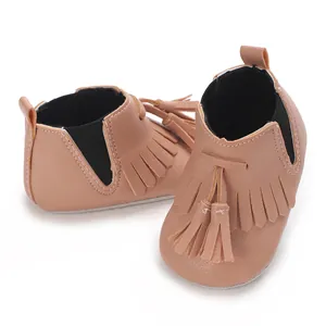 Detailansicht der Baby-Stiefeletten mit dekorativen Fransen und weichen Stoffsohlen.
