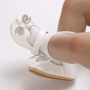 Detailed view of white baby girl princess walker shoes with sparkling rhinestone heart bow