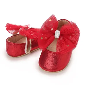 Detail van rode glitter babyschoen met tule strik en gouden sterren decoratie