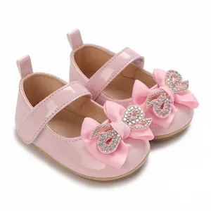 Close-up of pink baby girl princess shoes with rhinestone bow and soft non-slip soles
