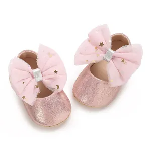 Detailopname van roze glitter babyschoentjes met sterrenpatroon mesh strik detail