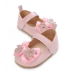 Close-up detail of pink baby girl princess walker shoes with bowknot and rhinestones