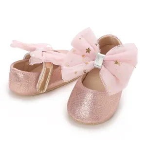Detailweergave van roze glitter baby prinsessenschoenen met een grote decoratieve tule strik