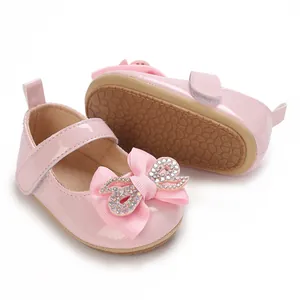Detail view of pink baby girl walking shoes featuring a sparkling rhinestone bow and non-slip sole