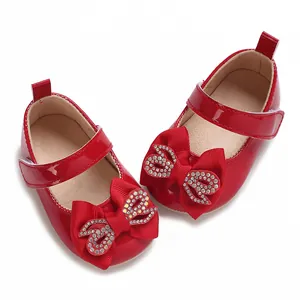 Glossy red patent leather baby girl toddler shoes featuring a rhinestone bow accent