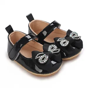 Elegant black patent leather baby girl walker shoes featuring a rhinestone bow detail