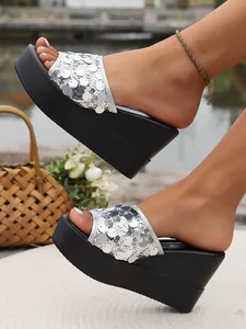 Detailed view of the sparkling silver sequins and thick platform sole on these wedge sandals.