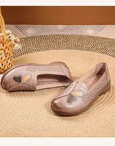 Detail of breathable leather loafers with butterfly embroidery and hollow patterns.