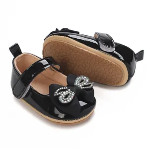 Detail of black baby girl walking shoes with rhinestone bow and soft rubber sole