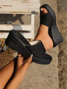 Vista detallada de elegantes sandalias de cuña negras con tira de purpurina
