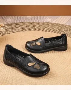 Close-up detail of black breathable leather flat mom shoes featuring fine butterfly embroidery