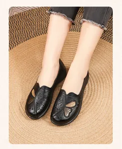 Detailed view of black leather summer flats with butterfly embroidery and hollow-out design