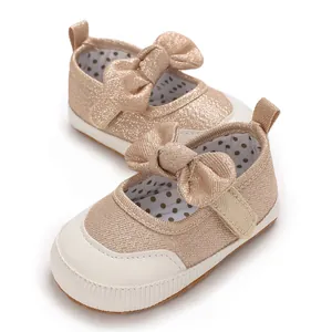 Detailed view of glittery rose gold baby walker shoes featuring a large bow and soft sole