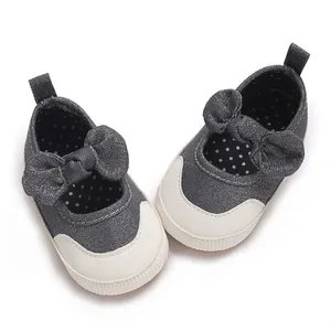 Detailed view of grey baby walking shoes with soft soles and decorative bows