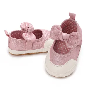 Detail view of pink glittery baby walking shoes with a soft sole and cute bow accent.
