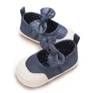 Close-up of blue denim baby walking shoes with bow and white toe cap