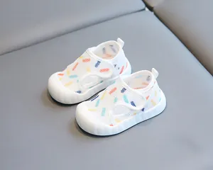 Gros plan de sandales bébés en maille blanche respirante avec motifs colorés et semelles souples