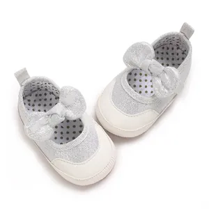 Detailed top-down view of silver baby walking shoes with decorative bows and polka dot lining