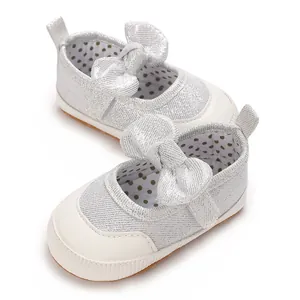 Close-up of silver glitter baby Mary Jane walking shoes with large bow detail